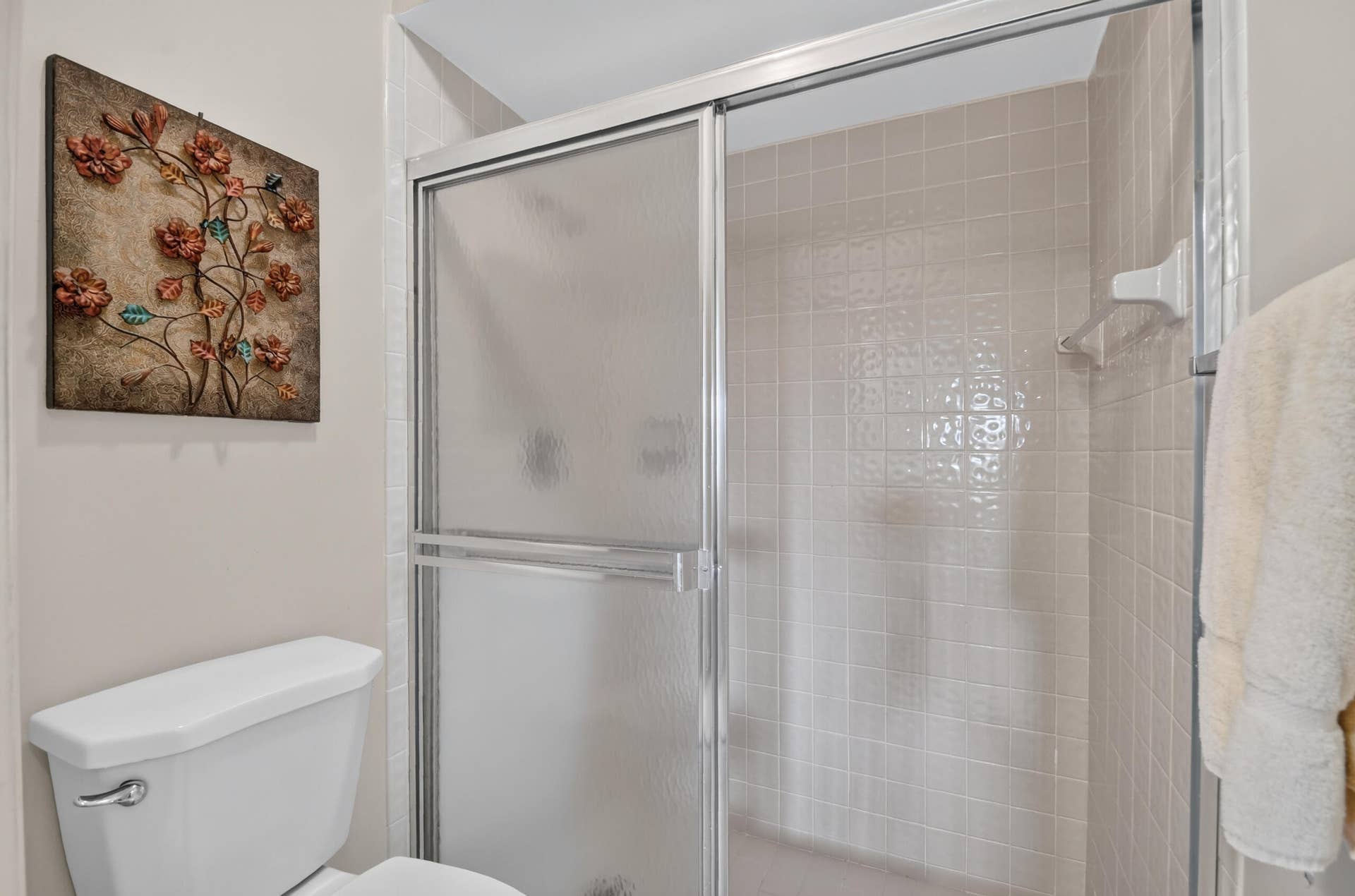 Shower enclosure with sliding frosted-glass doors and tiled surround