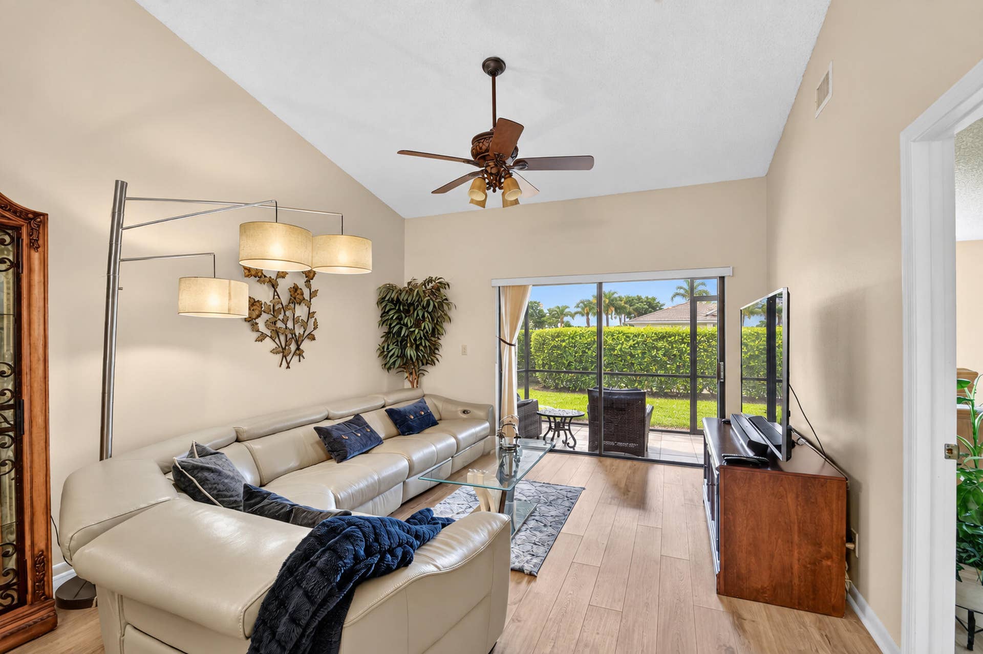 Vaulted ceilings, wood-finish flooring, and glass sliding doors providing exterior exposure