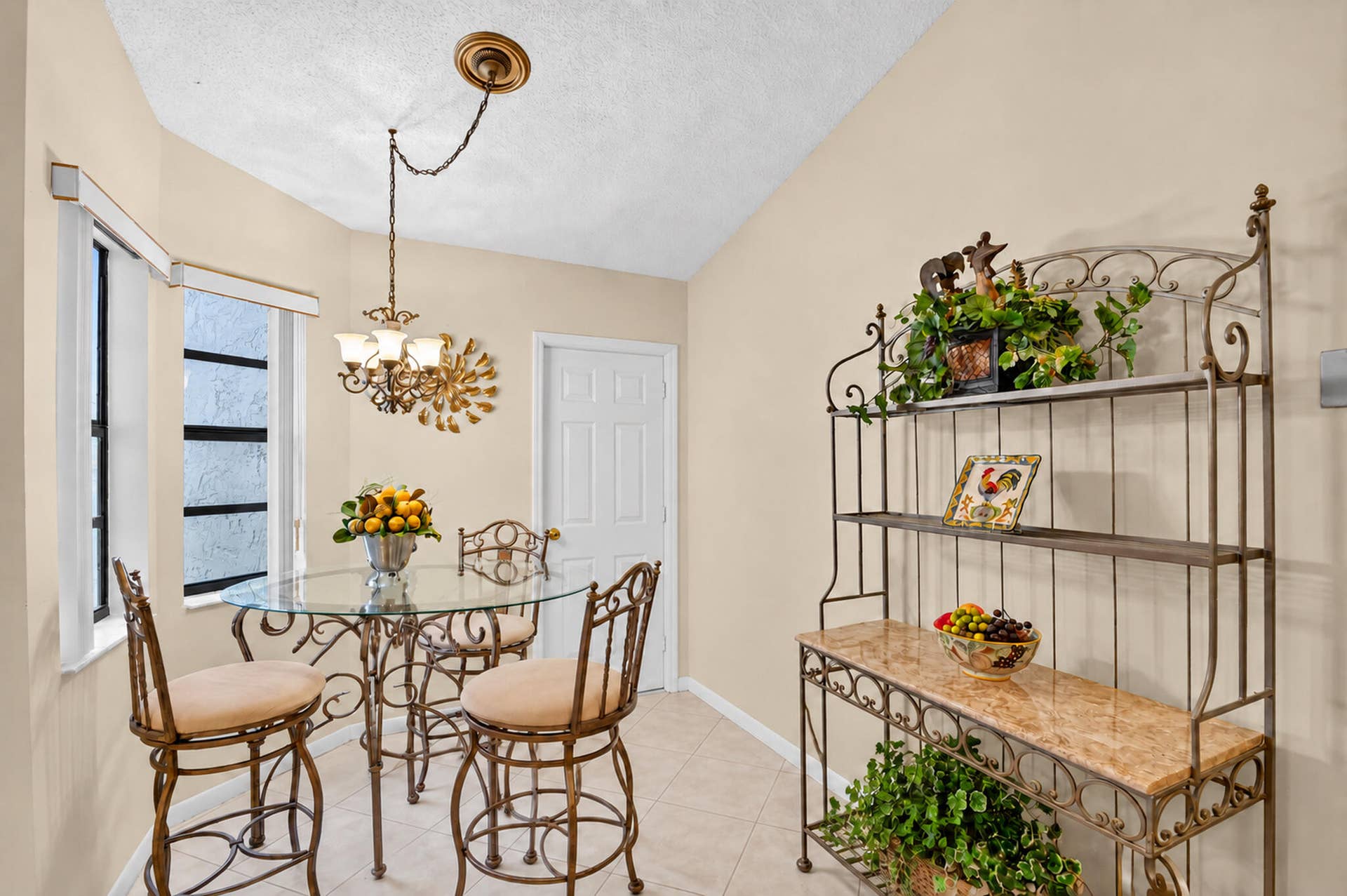 Neutral wall tones, ceramic tile flooring, and a multi-light chandelier featuring a gold-tone finish