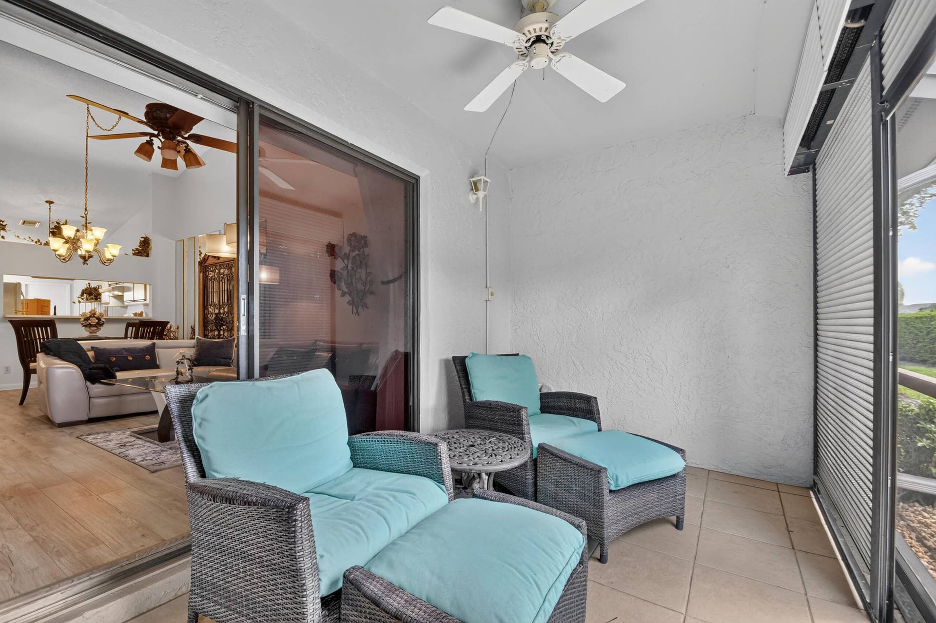 Covered patio featuring ceramic tile flooring, a ceiling-mounted fan, and floor-to-ceiling sliding glass doors