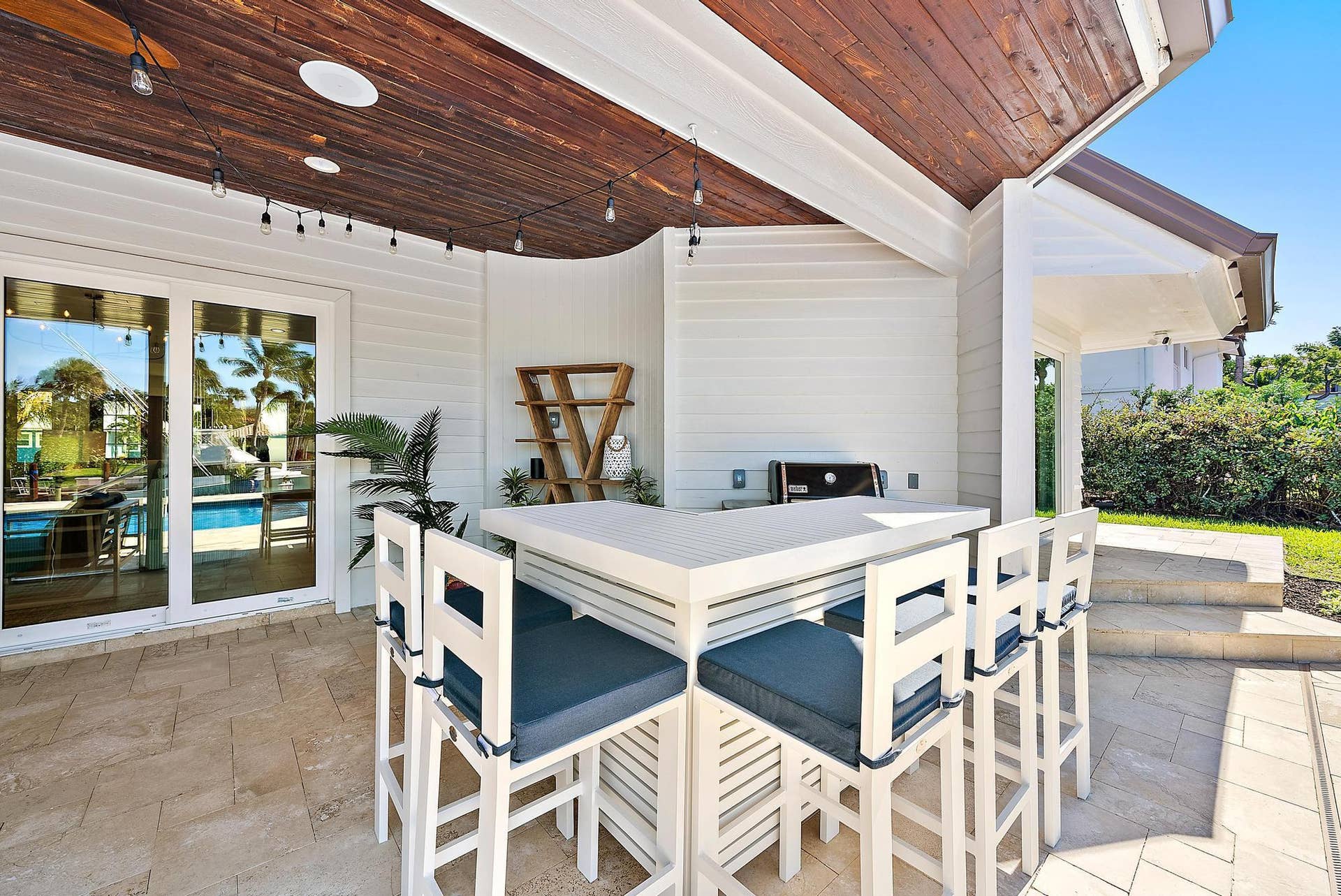 Covered patio featuring a wood-plank ceiling, built-in stone-top bar, recessed lighting, and stone paver flooring