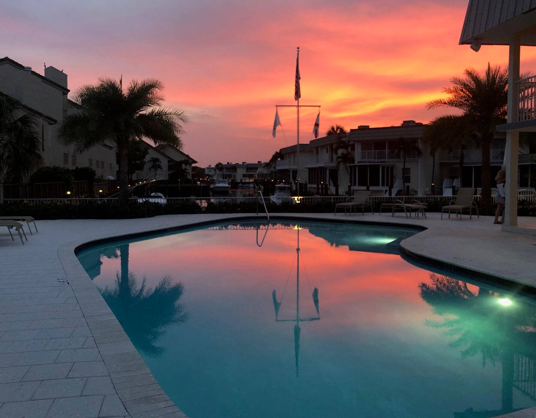 1127 BOCA COVE Lane, Highland Beach, FL 33487 Curved swimming pool with integrated lighting, surrounded by a paved patio