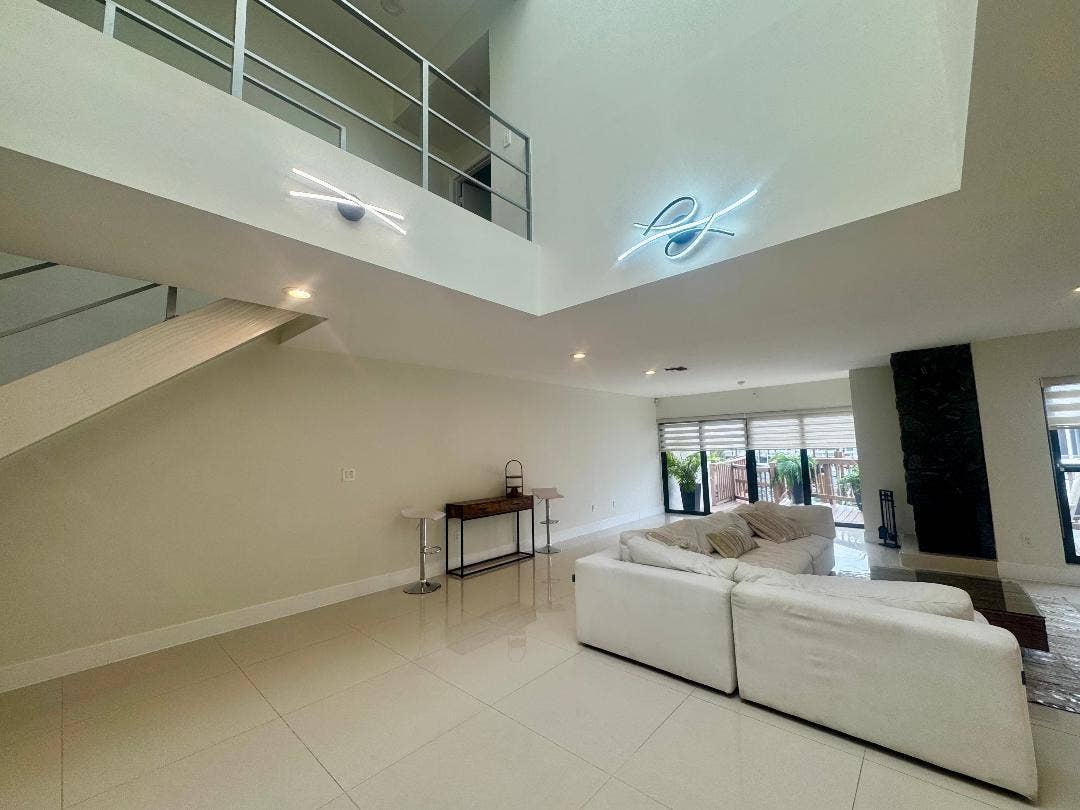 1127 BOCA COVE Lane, Highland Beach, FL 33487 High ceilings with recessed lighting, tile flooring, and a second-story balcony with metal railings