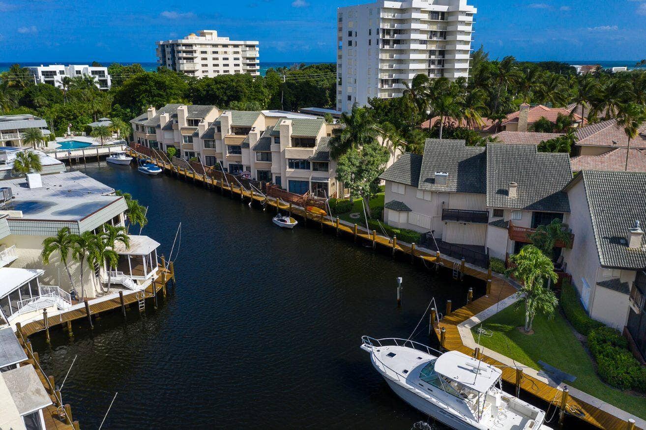 1127 BOCA COVE Lane, Highland Beach, FL 33487 Waterfront property with private dock, channel access, and multi-story residences