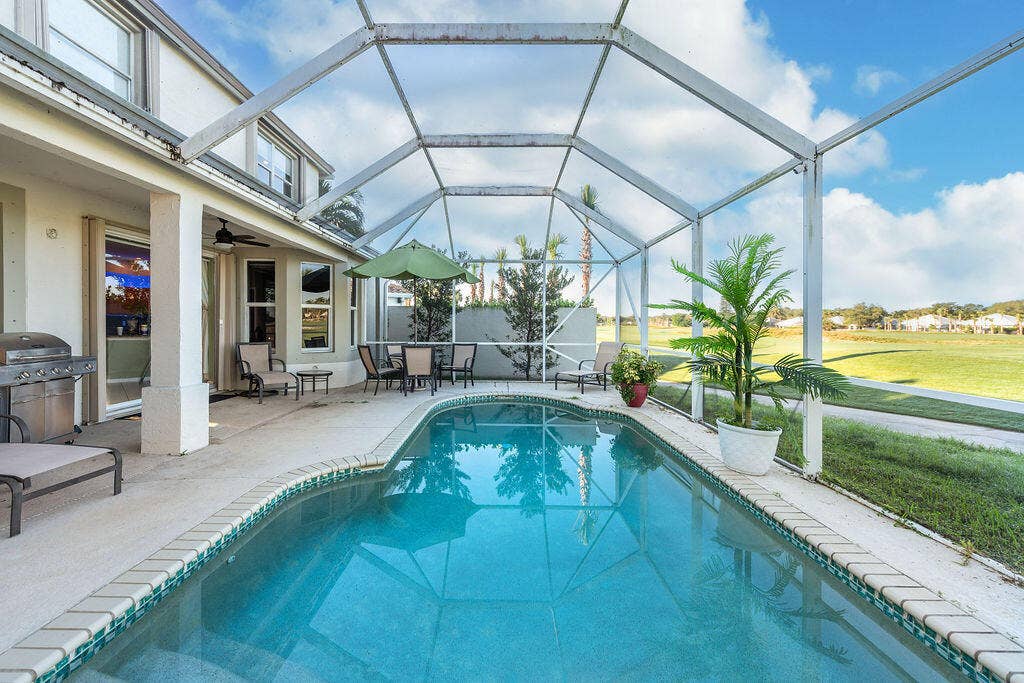 1233 Avondale Lane, West Palm Beach, FL 33409 Screen-enclosed patio featuring a concrete pool deck, integrated swimming pool, and covered porch area