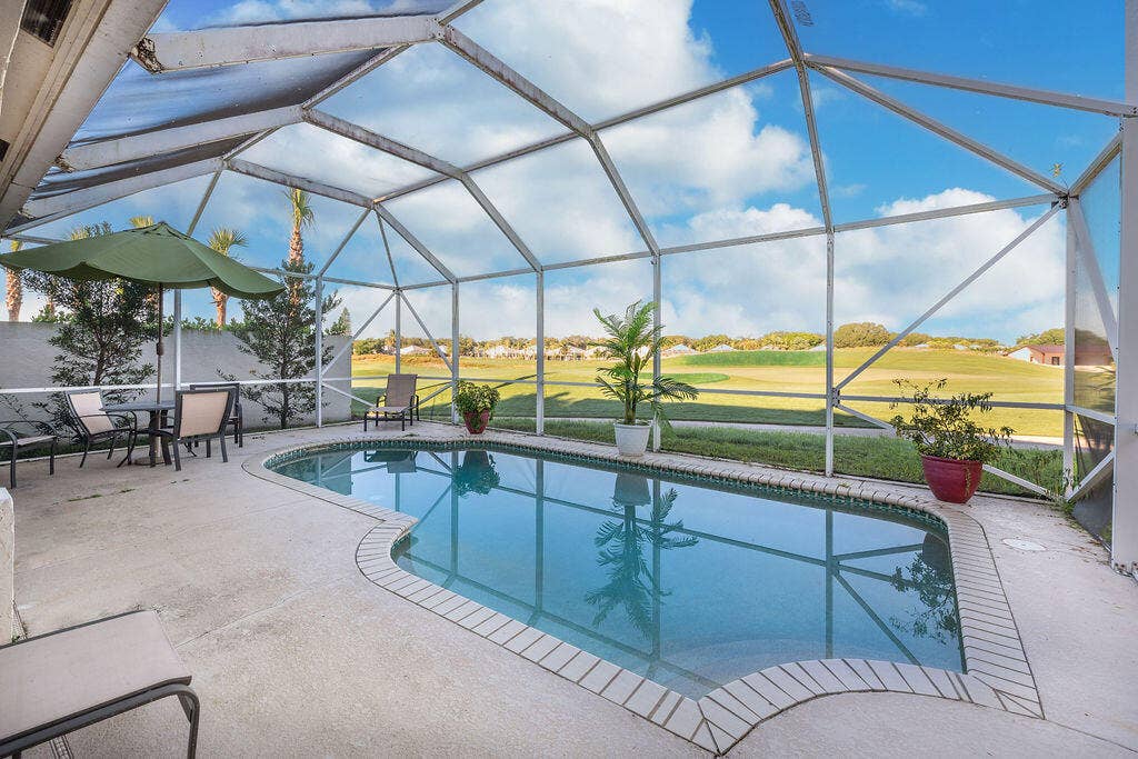 1233 Avondale Lane, West Palm Beach, FL 33409 Screened-in patio area featuring a concrete deck and a private in-ground swimming pool