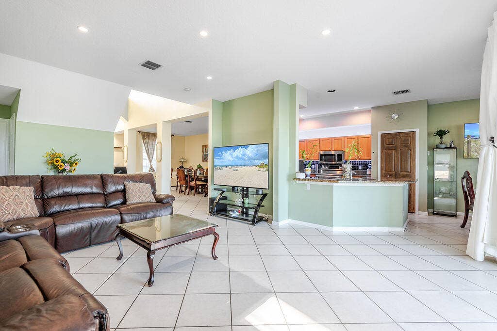 1233 Avondale Lane, West Palm Beach, FL 33409 Open-concept interior featuring light-toned diagonal tile flooring, recessed ceiling lighting, a pass-through kitchen counter, and wood-finish cabinetry