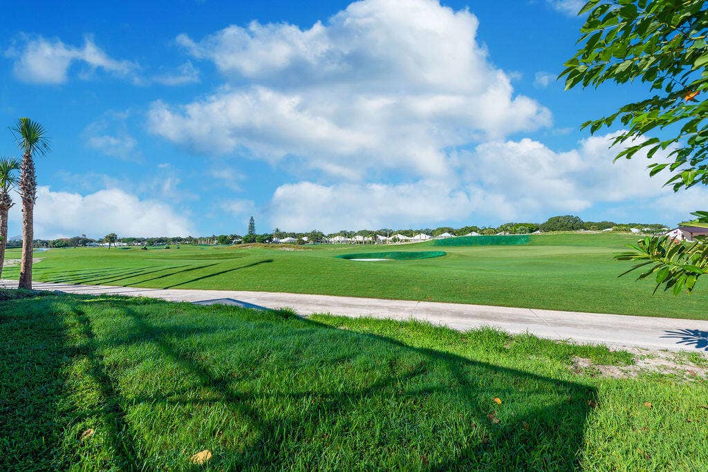 1233 Avondale Lane, West Palm Beach, FL 33409 Expansive golf course scenery featuring manicured green fairways, sand bunkers, and mature palm trees