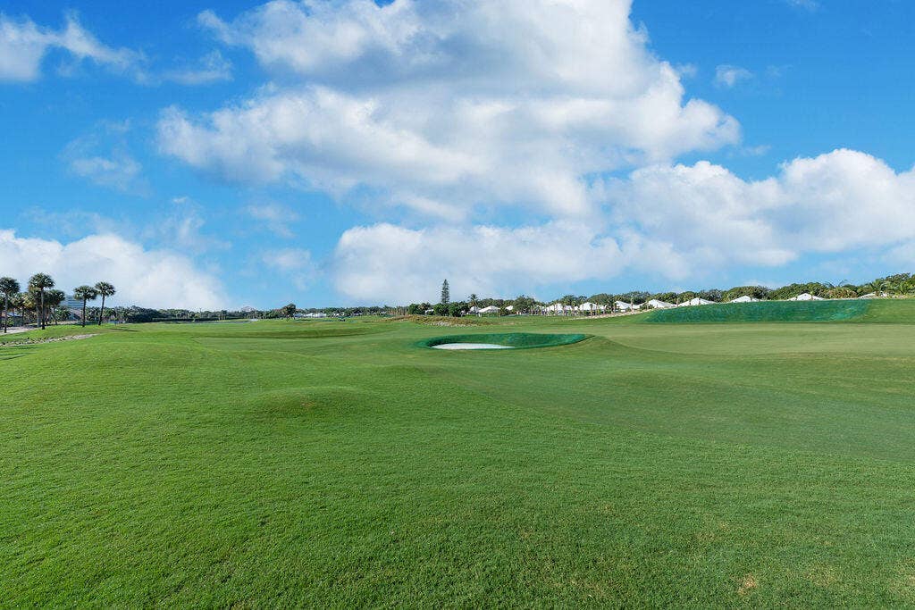 1233 Avondale Lane, West Palm Beach, FL 33409 Expansive golf course grounds featuring manicured turf, sand bunkers, and mature palm trees