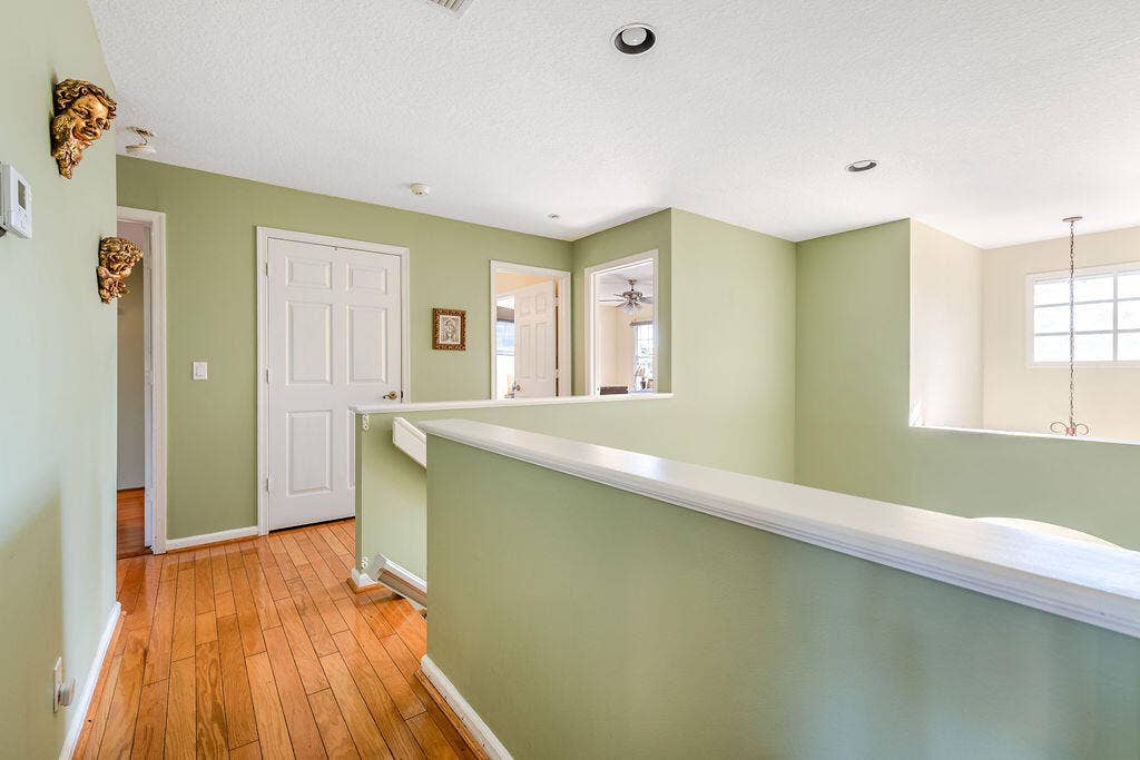 1233 Avondale Lane, West Palm Beach, FL 33409 Interior hallway featuring wood-finish flooring, recessed lighting, and a partial wall with a cap rail
