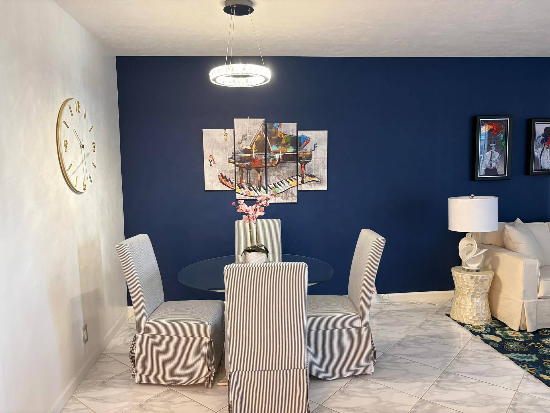 Large-format stone-finish floor tiles and a circular modern pendant light fixture with integrated illumination