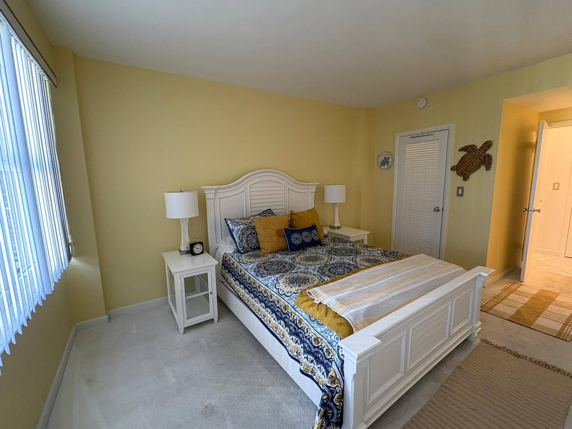 Bedroom featuring wall-to-wall carpeting, vertical blinds, and a louvered closet door
