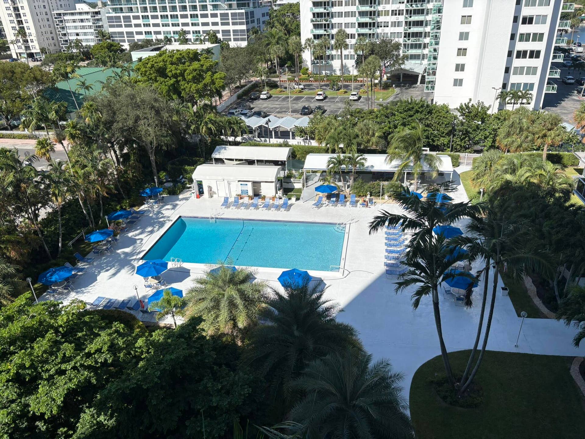 Swimming pool with concrete deck, covered pavilion, and mature landscaping