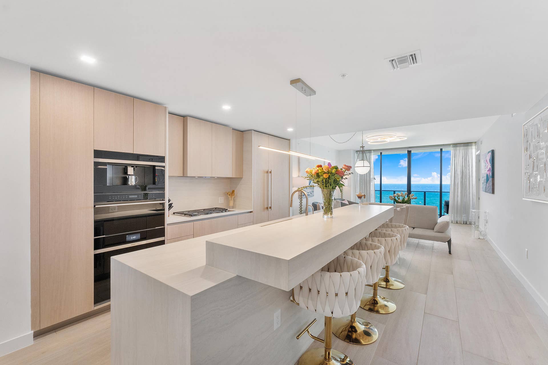 900 N OCEAN Boulevard, #1204, Pompano Beach, FL 33062 A stunning designer kitchen featuring sleek contemporary cabinetry, premium finishes, and an expansive island, perfectly complemented by breathtaking ocean views.