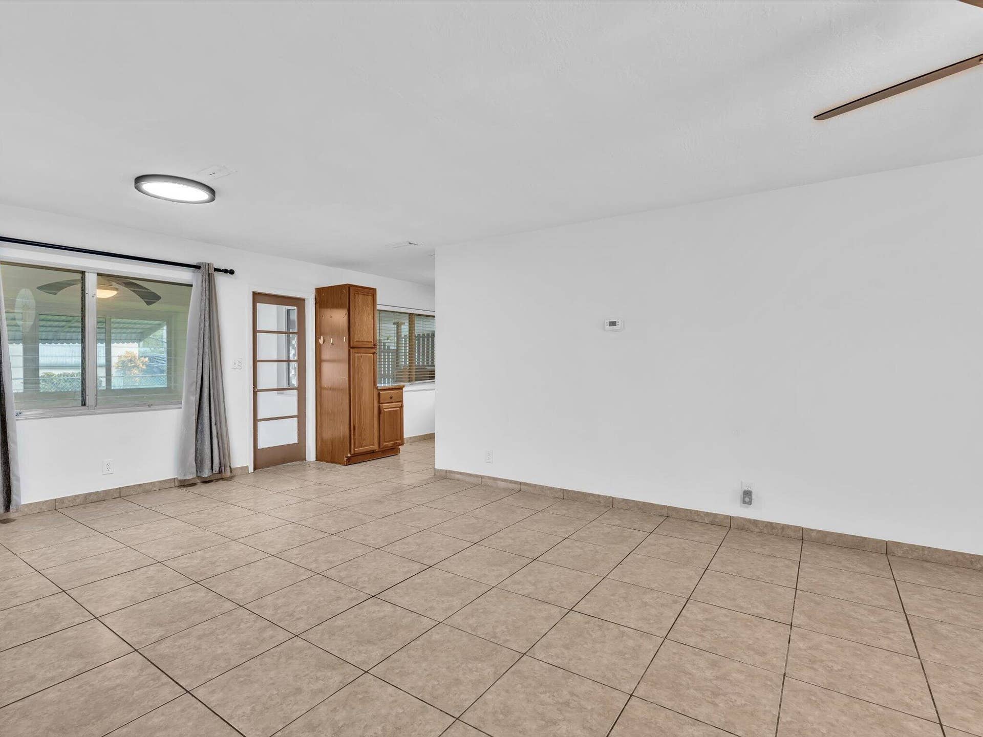 132 SE 2ND Court, Dania Beach, Dania Beach, FL 33004 Interior space featuring neutral ceramic tile flooring, built-in floor-to-ceiling wooden cabinetry, a multi-pane glass door, and recessed lighting