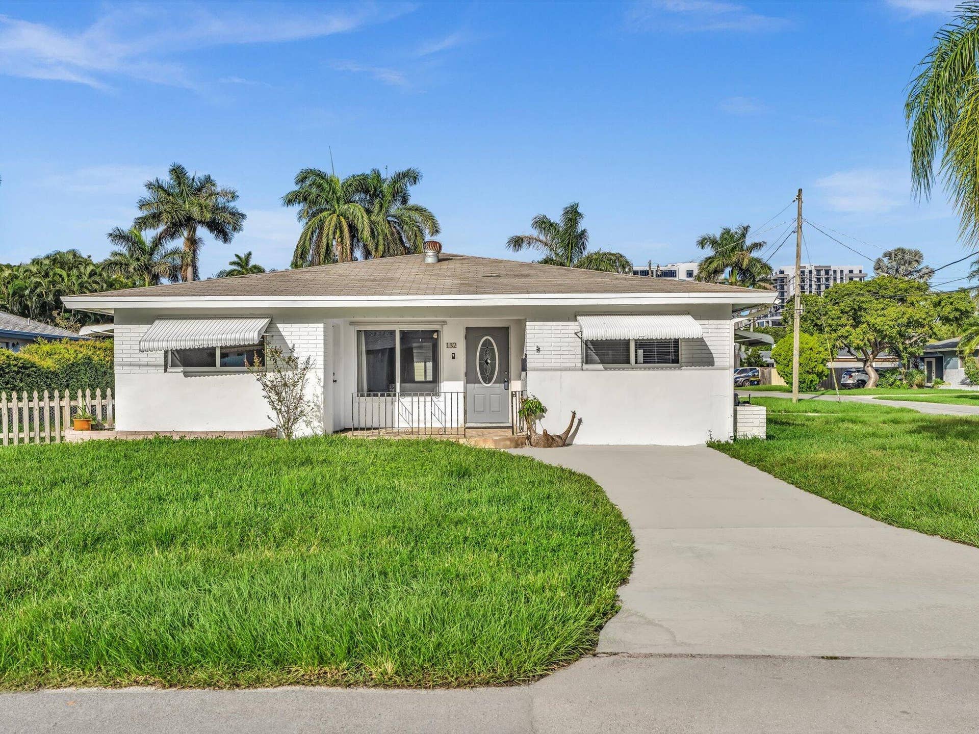 132 SE 2ND Court, Dania Beach, Dania Beach, FL 33004 Single-story exterior featuring a painted brick facade, metal window awnings, and a concrete driveway