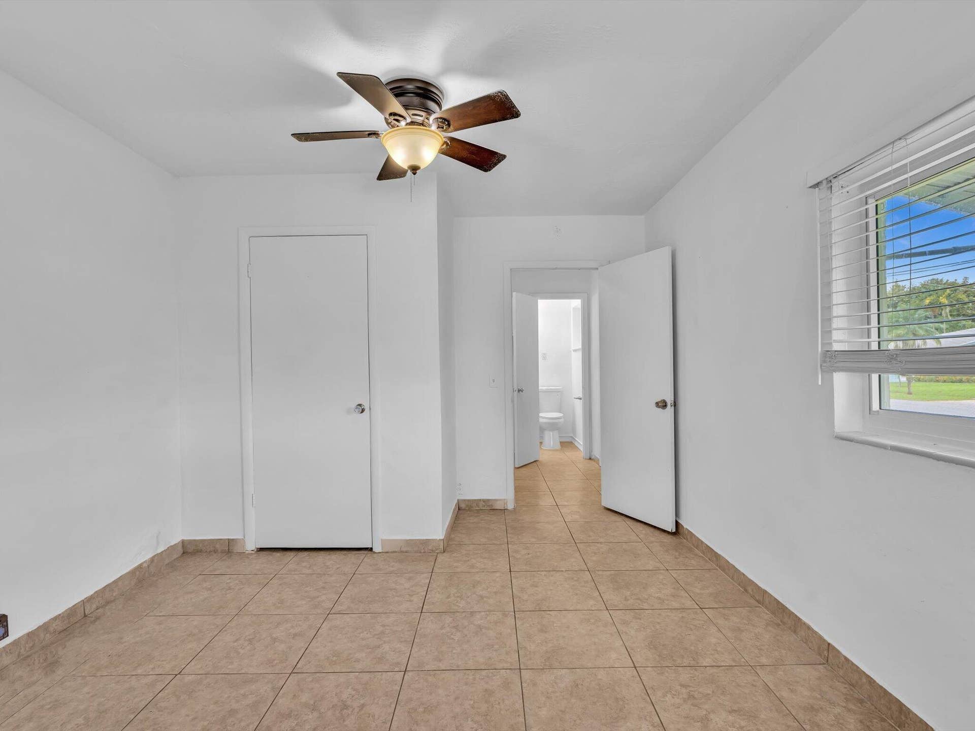 132 SE 2ND Court, Dania Beach, Dania Beach, FL 33004 Room interior featuring ceramic tile flooring, a multi-blade ceiling fan with integrated lighting, and horizontal window blinds