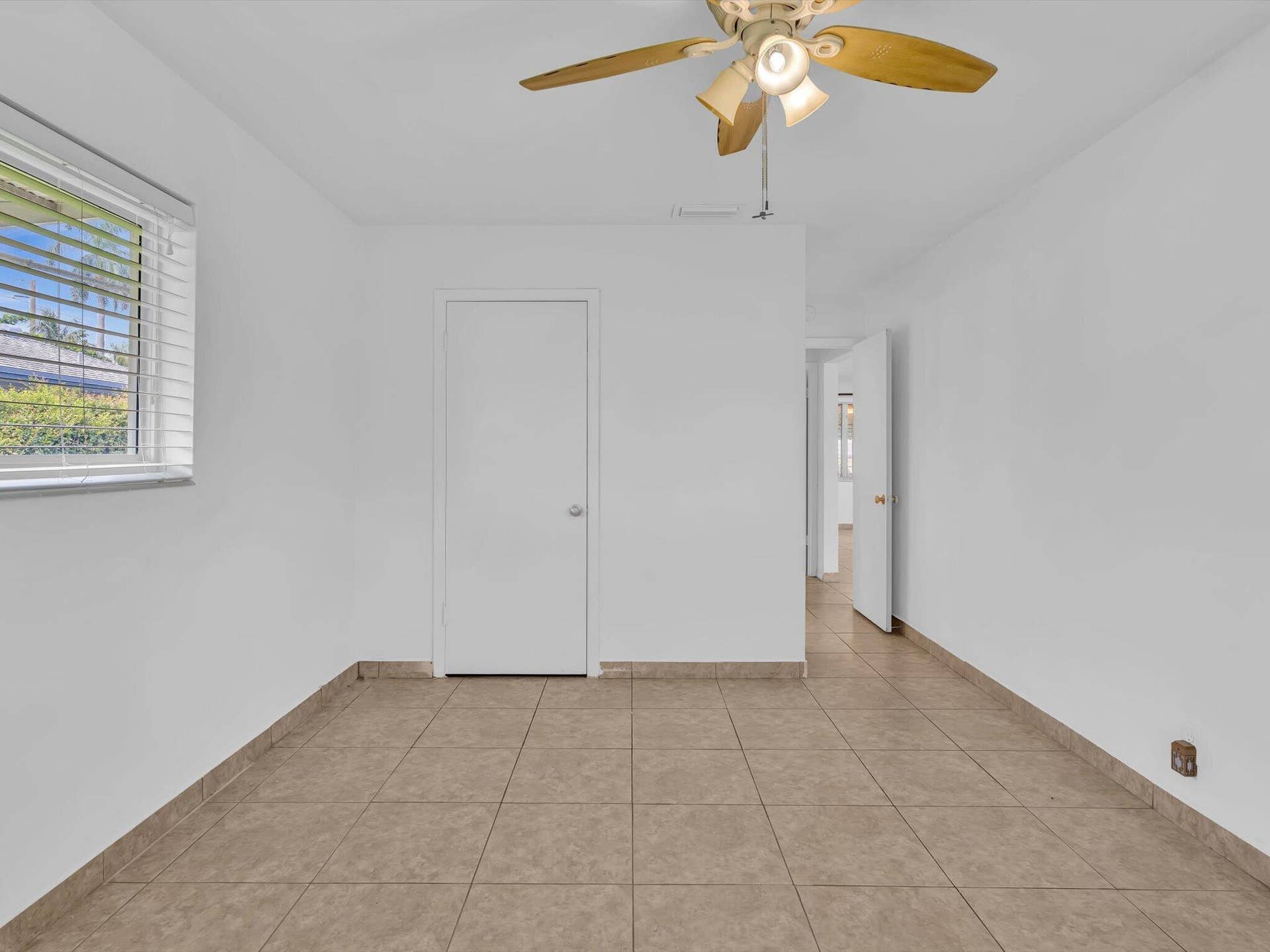 132 SE 2ND Court, Dania Beach, Dania Beach, FL 33004 Interior room featuring large-format tile flooring, a multi-blade ceiling fan with integrated light fixture, a single-panel interior door, and a horizontal window with blinds