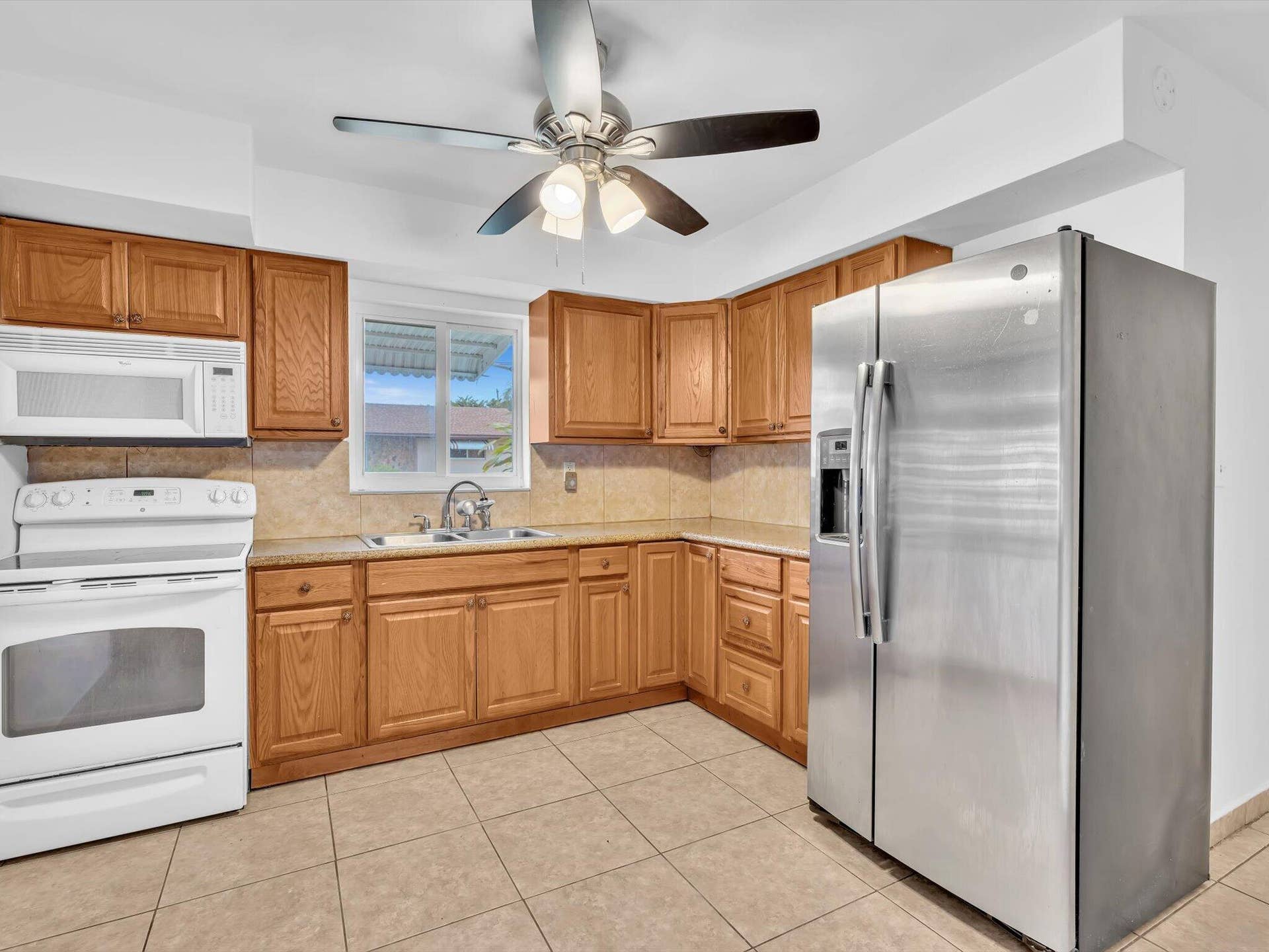 132 SE 2ND Court, Dania Beach, Dania Beach, FL 33004 Kitchen featuring wood cabinetry, stainless steel side-by-side refrigerator, white appliance suite, tile flooring, and a ceiling fan
