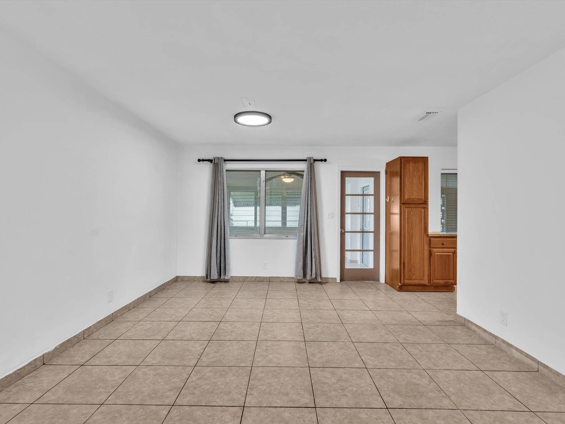 132 SE 2ND Court, Dania Beach, Dania Beach, FL 33004 Neutral-toned tile flooring, single-lite glass entry door, flush-mount lighting, and built-in wood cabinetry