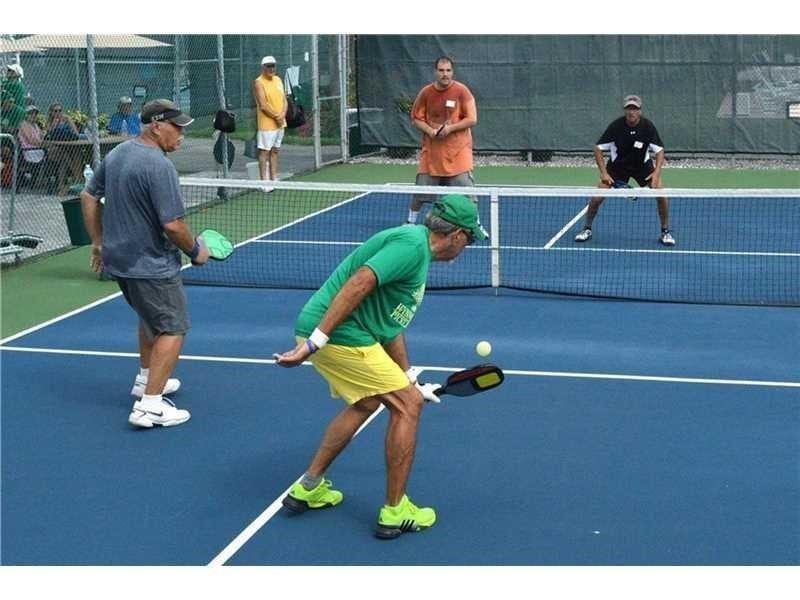 2305 LUCAYA Lane, #L4, Coconut Creek, Coconut Creek, FL 33066 Professional-grade pickleball court featuring a high-traction blue acrylic surface, white regulation court markings, and perimeter chain-link fencing