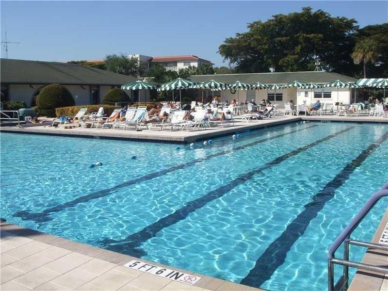 2305 LUCAYA Lane, #L4, Coconut Creek, Coconut Creek, FL 33066 Large swimming pool featuring multi-lane markings, a tiled perimeter, and metal entry handrails