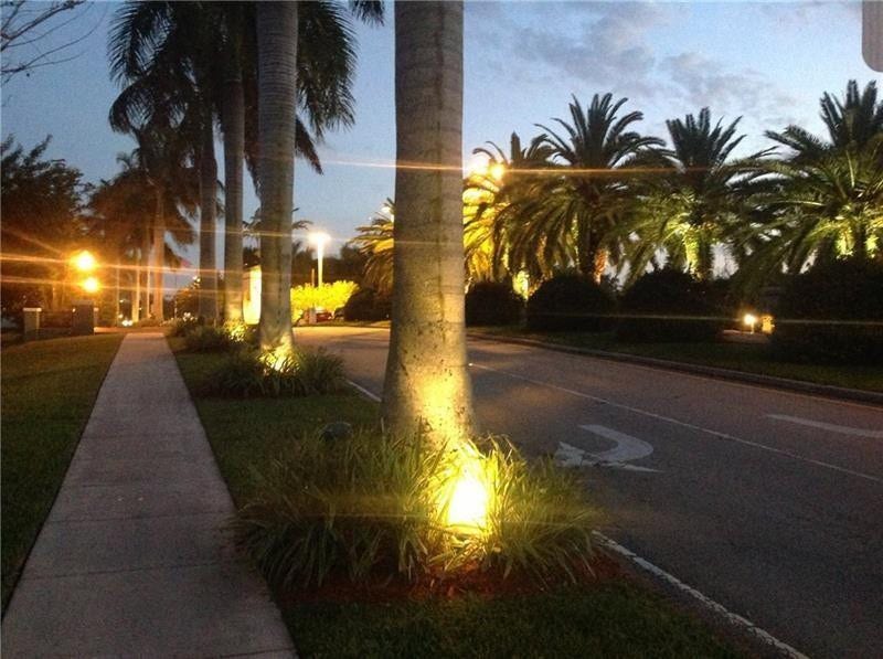 2305 LUCAYA Lane, #L4, Coconut Creek, Coconut Creek, FL 33066 Asphalt roadway lined with mature palm trees, concrete sidewalk, and landscape up-lighting
