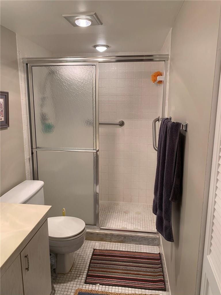 2305 LUCAYA Lane, #L4, Coconut Creek, Coconut Creek, FL 33066 Bathroom featuring a walk-in shower with a chrome-framed sliding glass door, tiled shower surround, recessed lighting, vanity with a countertop, and mosaic tile flooring