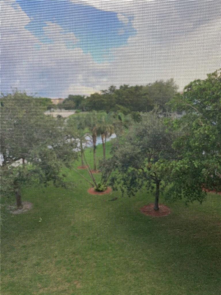 2305 LUCAYA Lane, #L4, Coconut Creek, Coconut Creek, FL 33066 Expansive outdoor space featuring mature trees, manicured lawn, water element, and integrated landscaping