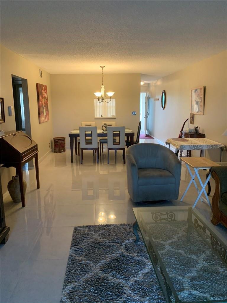 2305 LUCAYA Lane, #L4, Coconut Creek, Coconut Creek, FL 33066 Open-concept interior featuring large-format tile flooring and a multi-light chandelier