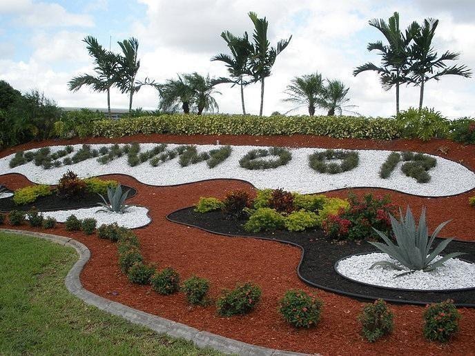 2305 LUCAYA Lane, #L4, Coconut Creek, Coconut Creek, FL 33066 Landscaped garden entry featuring tiered mulch beds, decorative white stone accents, mature palm trees, and assorted shrubbery