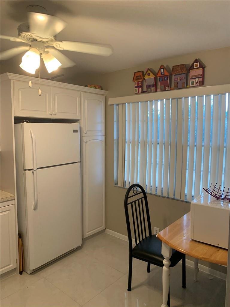 2305 LUCAYA Lane, #L4, Coconut Creek, Coconut Creek, FL 33066 White cabinetry with integrated pantry storage, ceiling-mounted light fixture with fan, and vertical window blinds