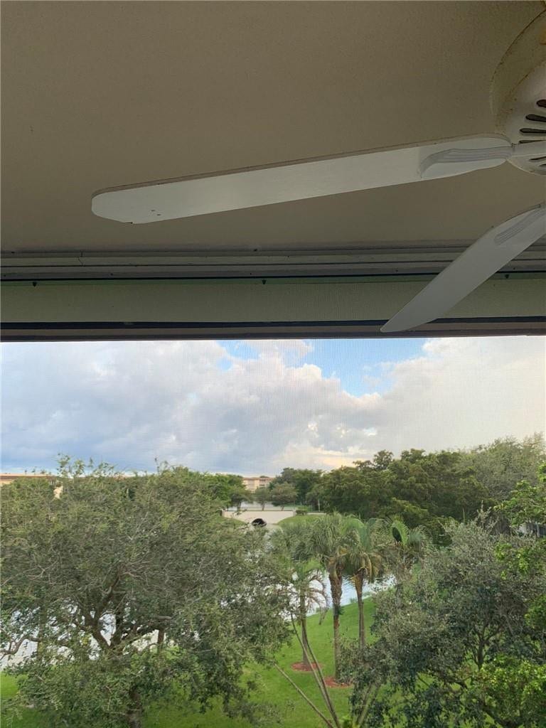 2305 LUCAYA Lane, #L4, Coconut Creek, Coconut Creek, FL 33066 Covered patio featuring a white ceiling-mounted fan, overlooking a water feature, bridge, and mature landscaping