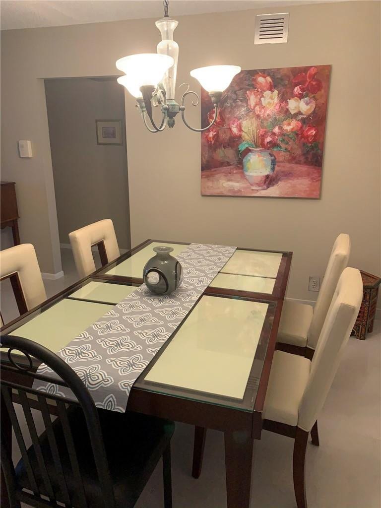 2305 LUCAYA Lane, #L4, Coconut Creek, Coconut Creek, FL 33066 Multi-light chandelier featuring a scrolled metal frame and frosted glass shades