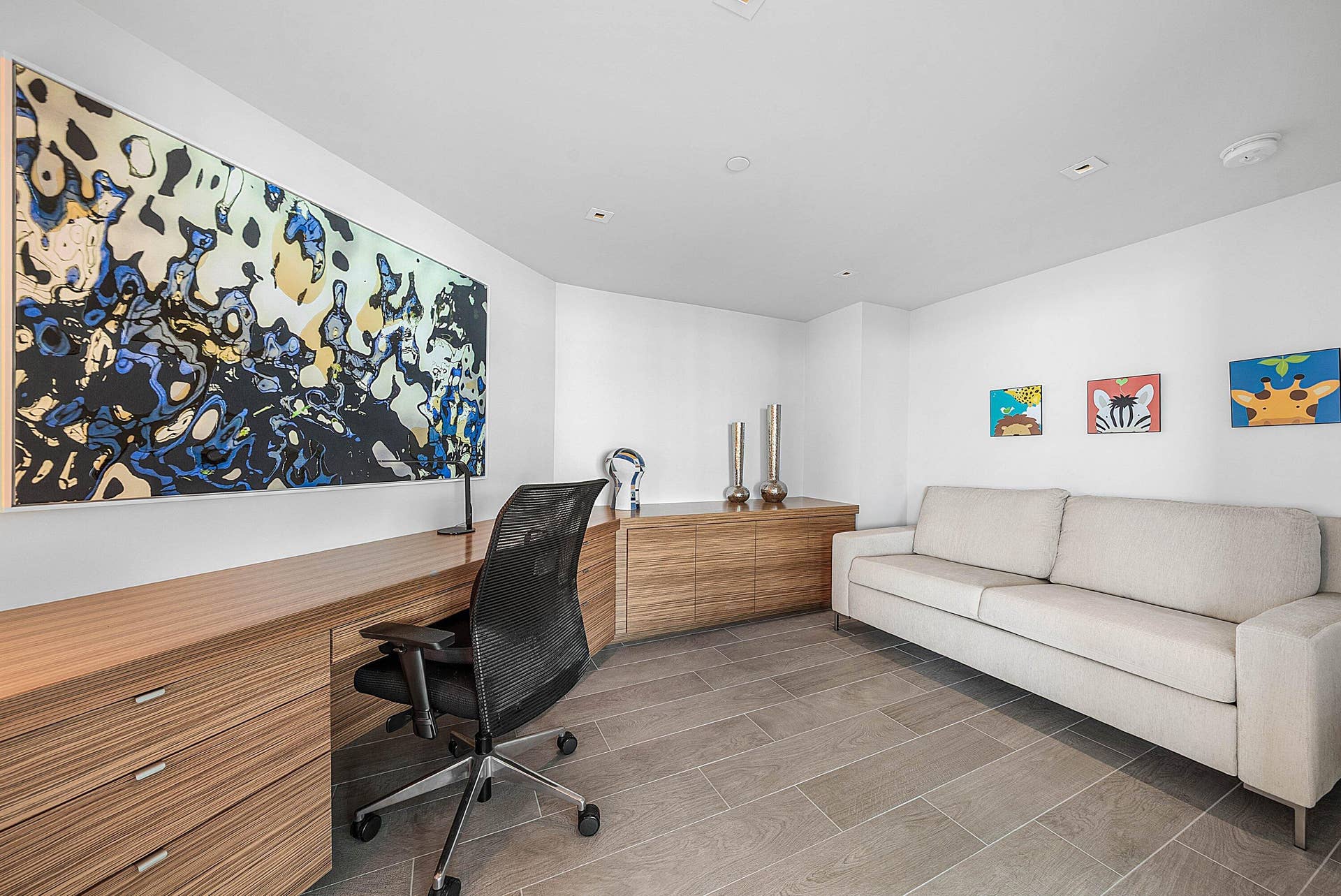Custom wood-finish built-in cabinetry, integrated desk workspace, recessed lighting, and large-format tile flooring