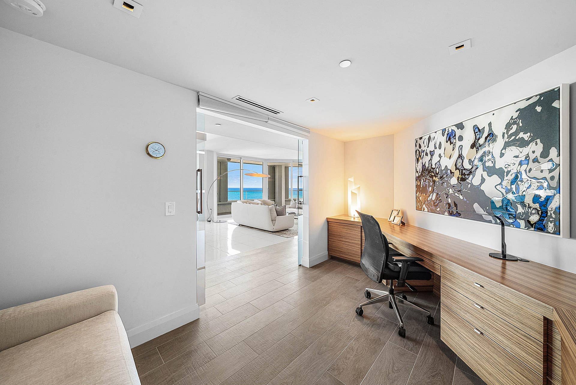 Built-in wood-finish cabinetry, recessed ceiling lighting, glass-paneled interior entry, and wood-finish flooring