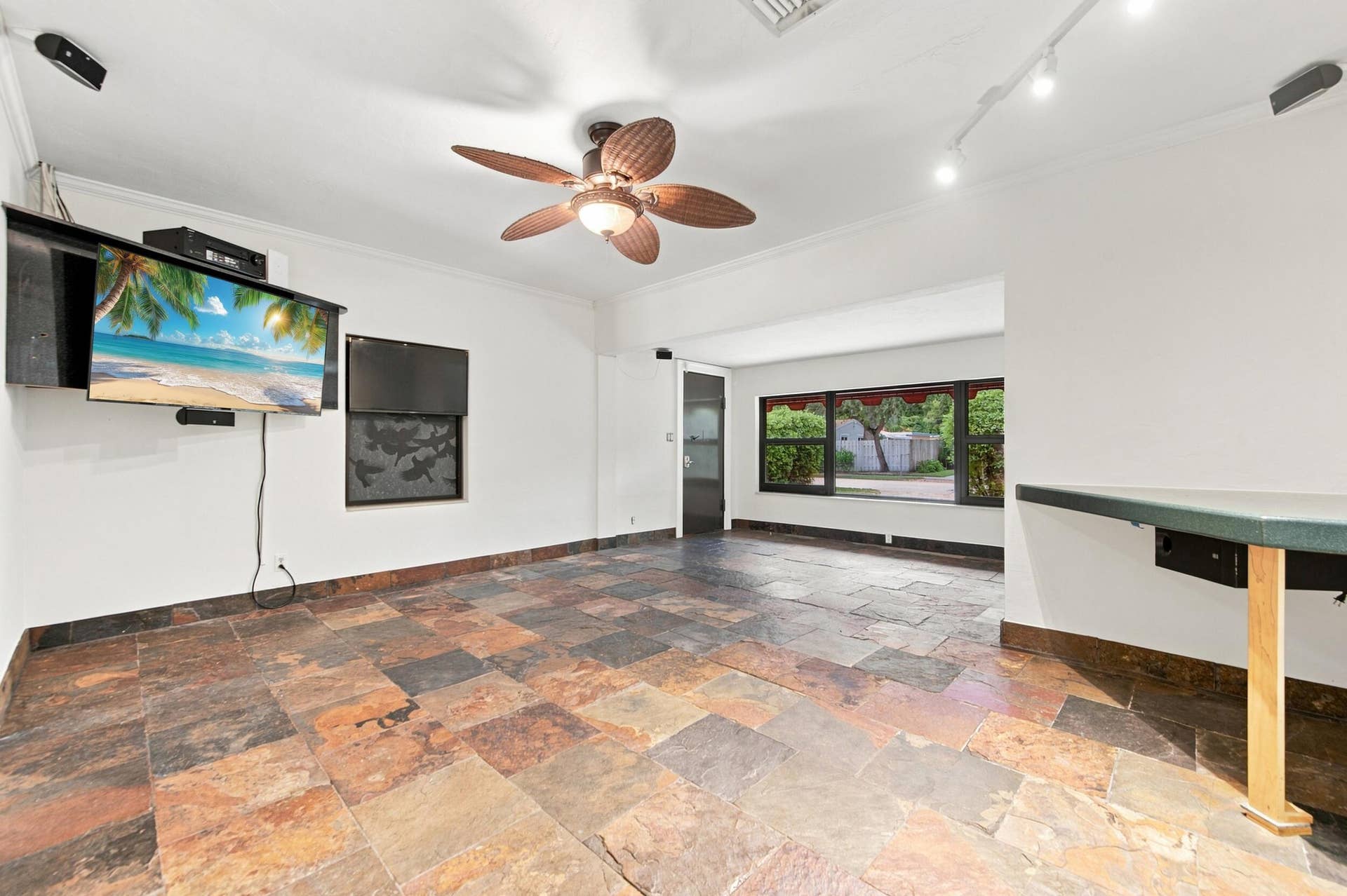 1110 SW 18TH Court, Fort Lauderdale, FL 33315 Multi-toned slate tile flooring, ceiling fan with palm-style blades, adjustable track lighting, and a built-in counter surface