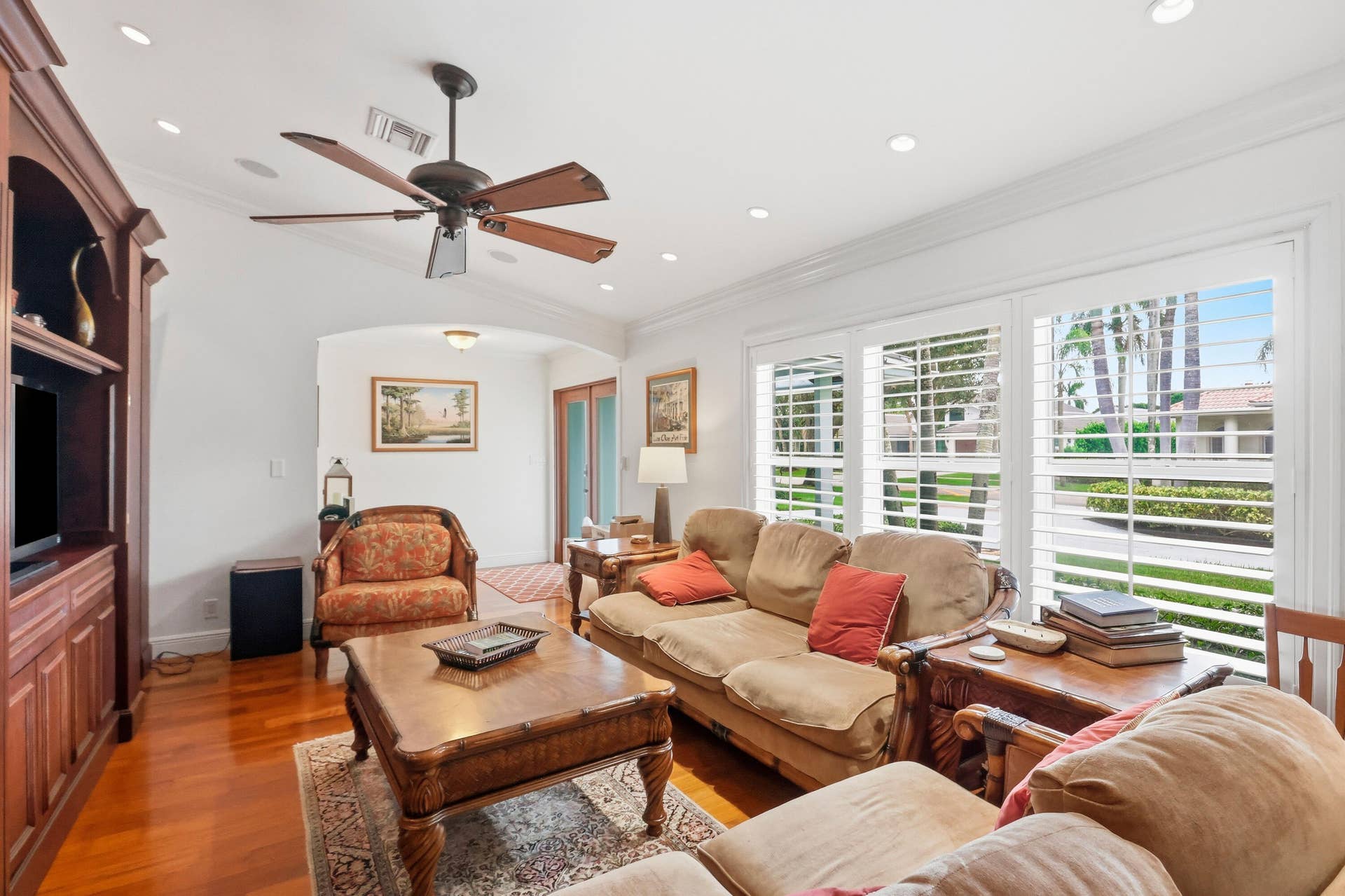 2919 Banyan Blvd Circle NW, Boca Raton, FL 33431 Living area featuring wood-finish flooring, recessed lighting, crown molding, plantation shutters, and built-in wooden cabinetry