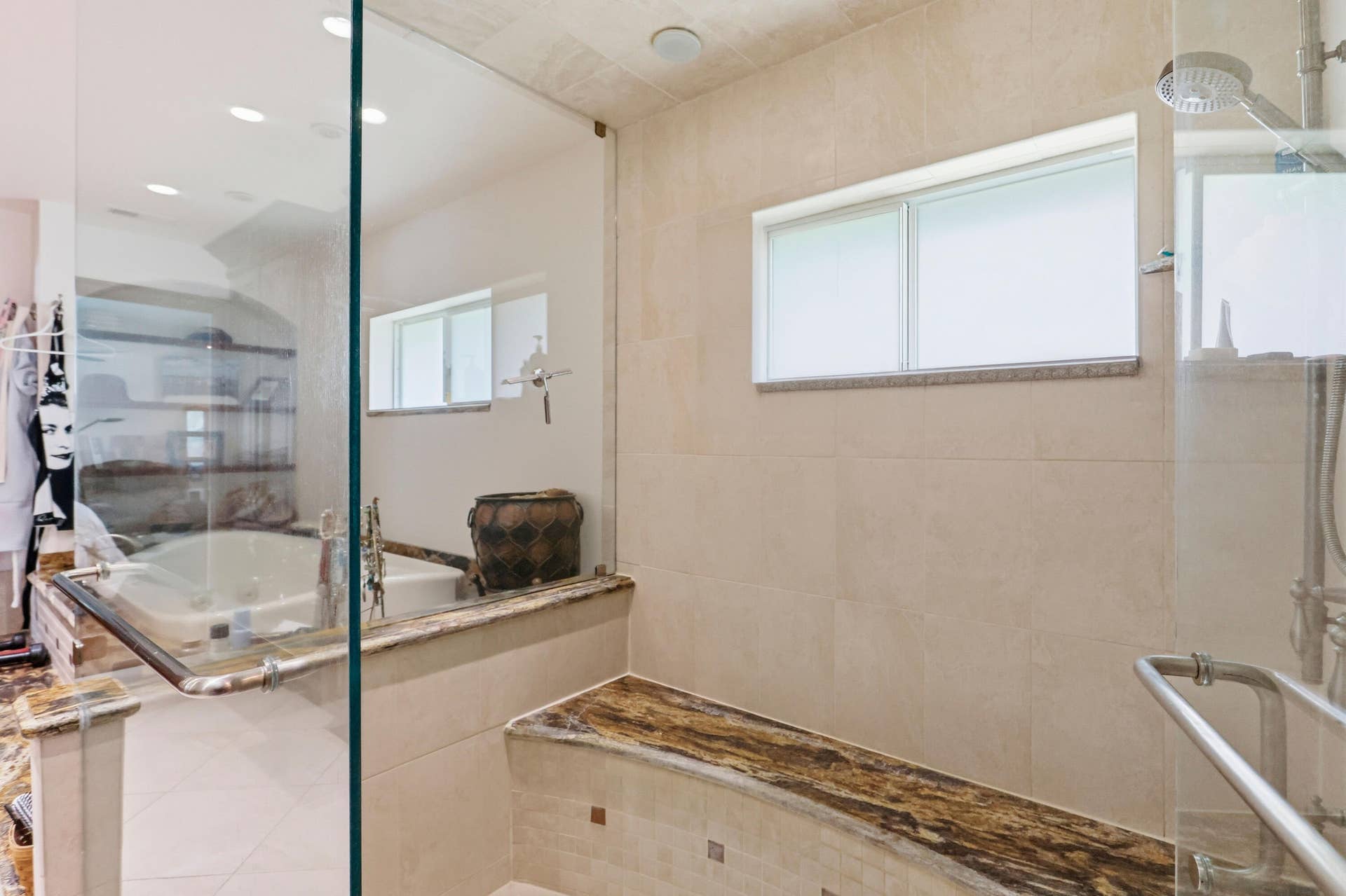 2919 Banyan Blvd Circle NW, Boca Raton, FL 33431 Walk-in shower featuring a glass enclosure, built-in stone bench, integrated rain shower head, and neutral large-format wall tile