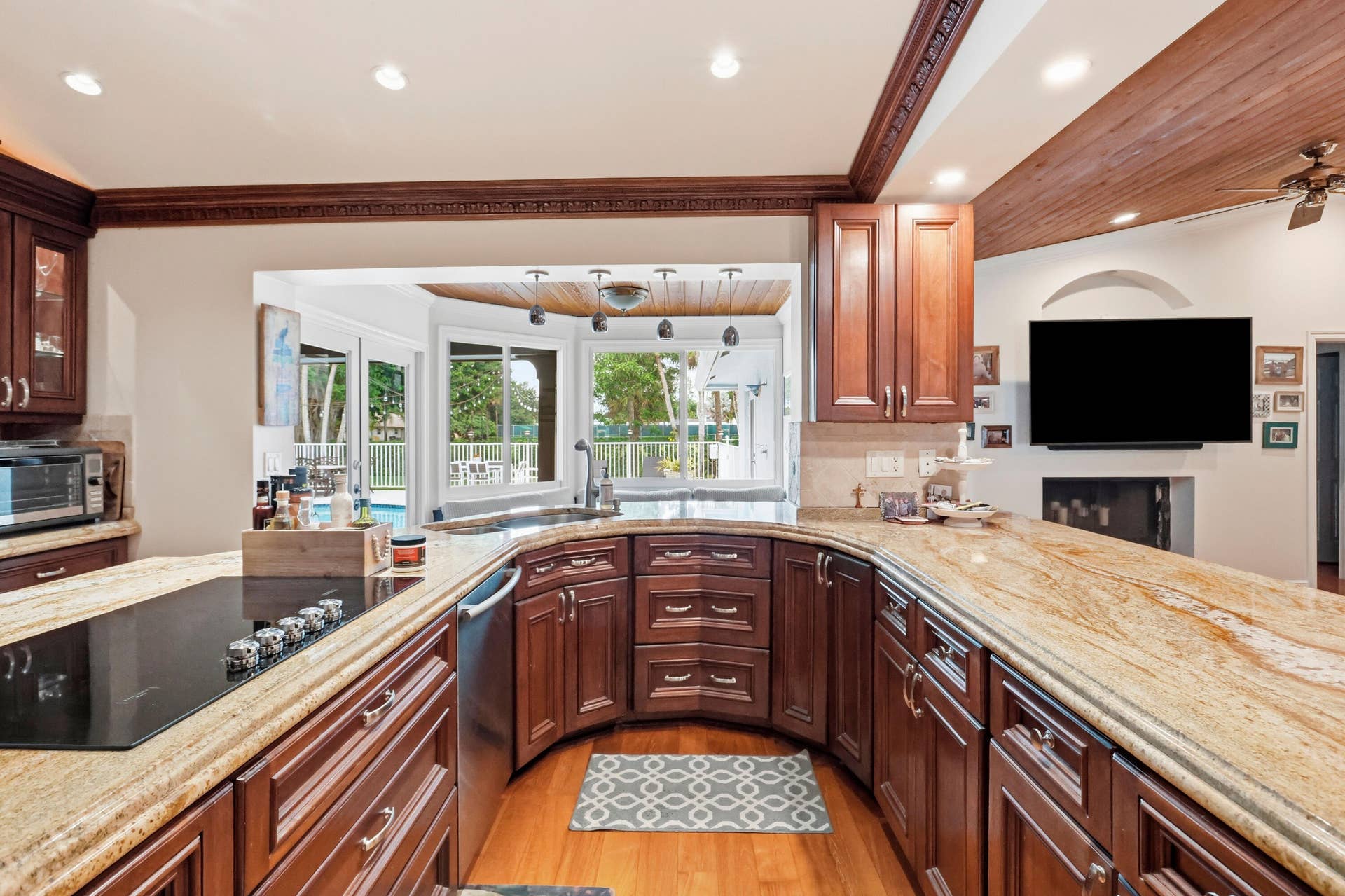 2919 Banyan Blvd Circle NW, Boca Raton, FL 33431 Kitchen featuring wood cabinetry, stone countertops, an integrated cooktop, recessed lighting, and a wood-paneled ceiling accent