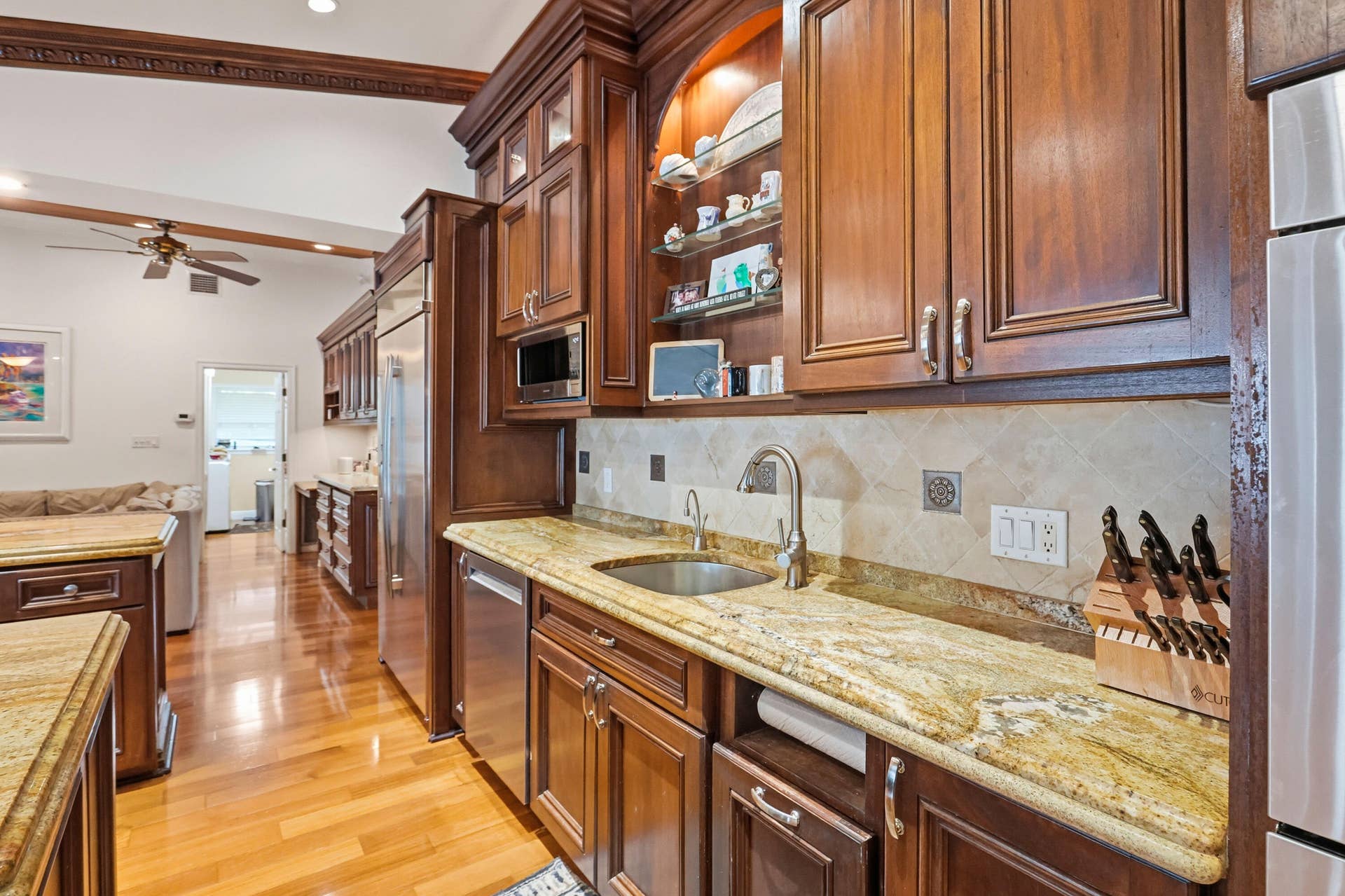 2919 Banyan Blvd Circle NW, Boca Raton, FL 33431 Kitchen featuring custom wood cabinetry, stone countertops, stone tile backsplash, stainless steel appliances, and wood-finish flooring