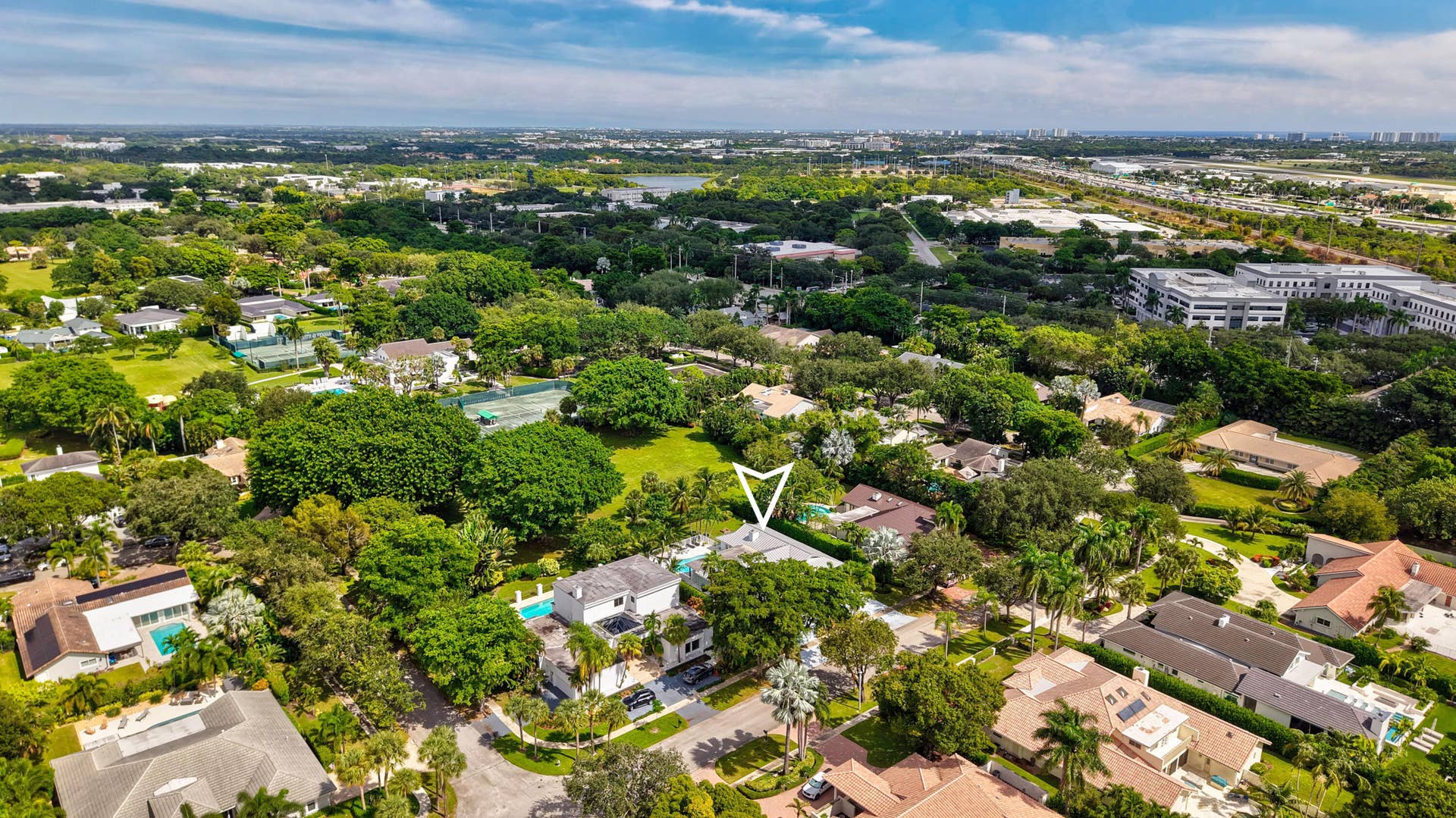 2919 Banyan Blvd Circle NW, Boca Raton, FL 33431 Aerial perspective of property featuring a private swimming pool, multi-level roofline, mature canopy trees, and paved driveway