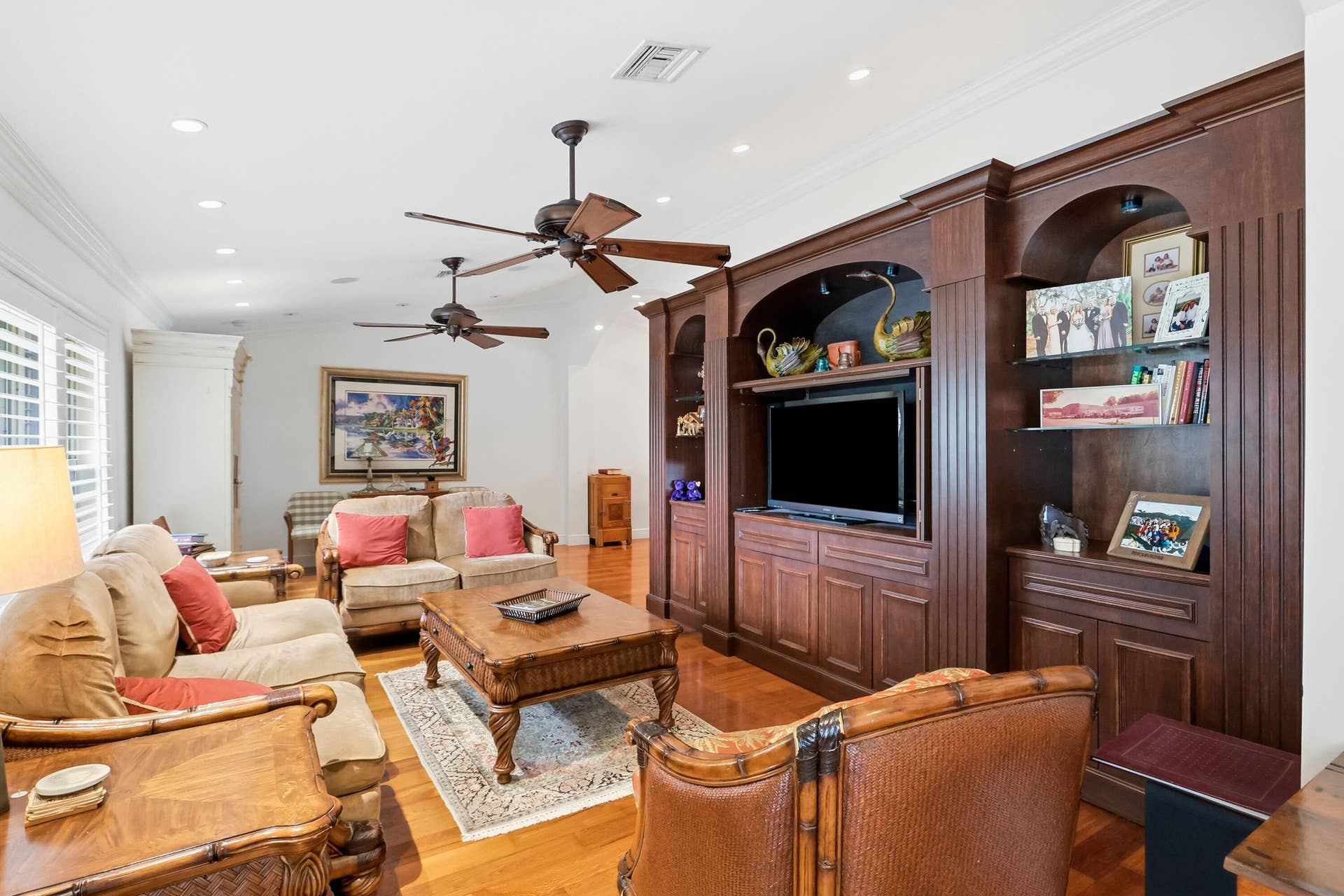 2919 Banyan Blvd Circle NW, Boca Raton, FL 33431 Custom wood-finish built-in cabinetry featuring arched display niches and integrated shelving, hardwood flooring, recessed ceiling lighting, and dual ceiling fans