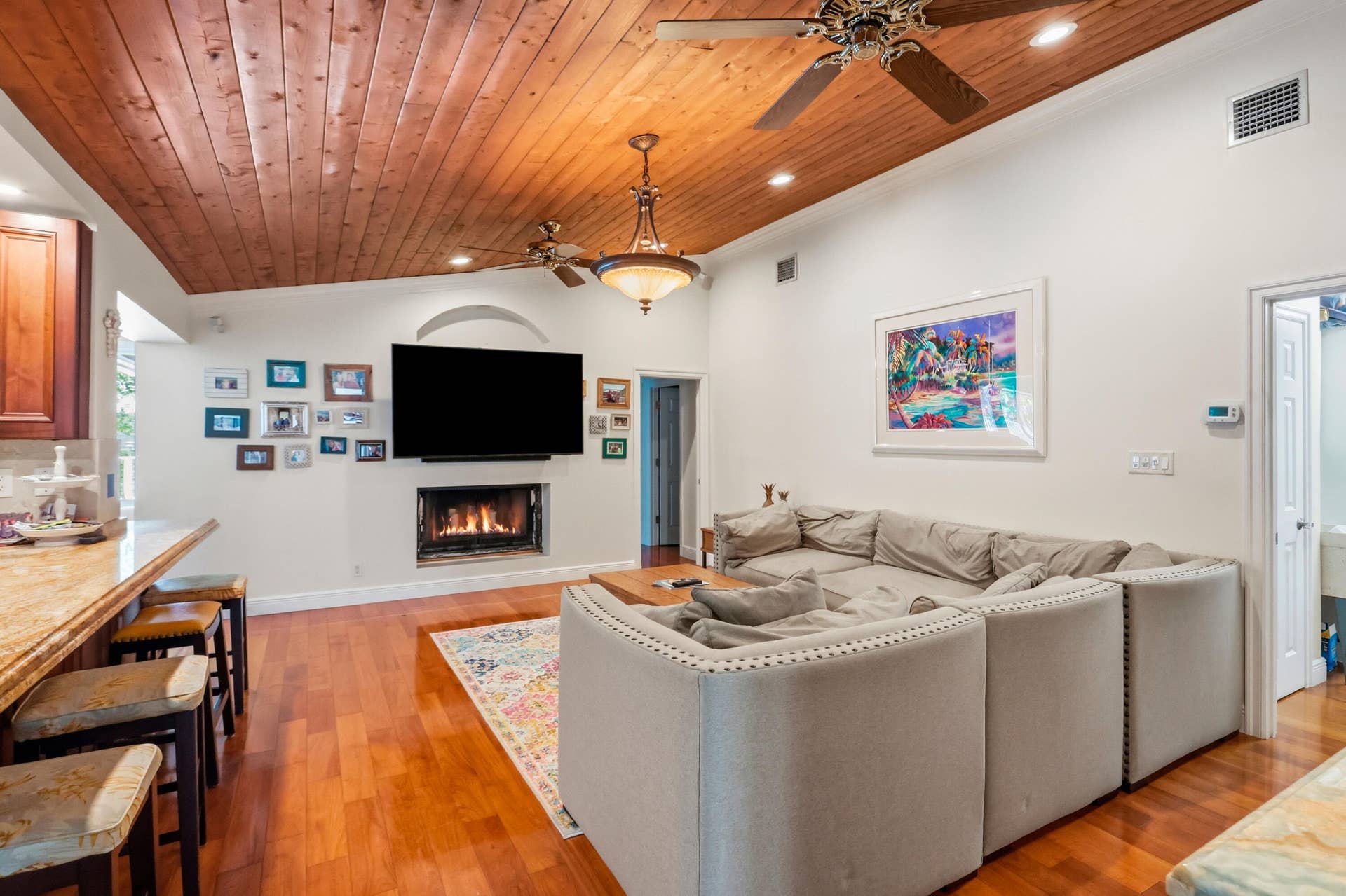 2919 Banyan Blvd Circle NW, Boca Raton, FL 33431 Vaulted wood-plank ceiling, wood-finish flooring, built-in fireplace, and integrated ceiling fan lighting