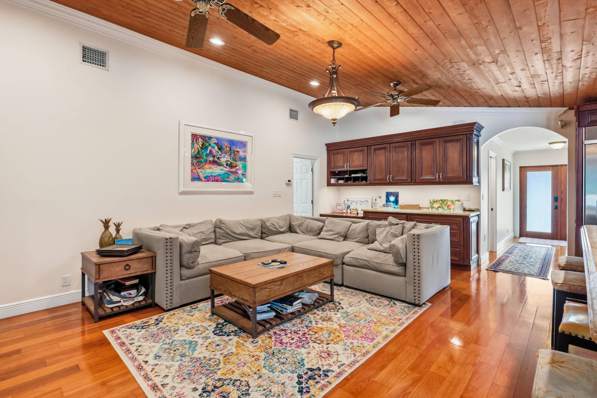 2919 Banyan Blvd Circle NW, Boca Raton, FL 33431 Vaulted tongue-and-groove wood ceiling featuring dual ceiling fans and a decorative chandelier, complemented by polished wood-finish flooring and built-in stained-wood cabinetry