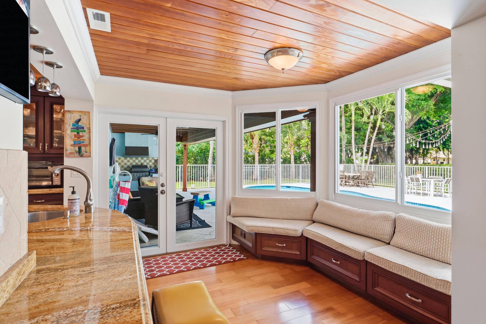 2919 Banyan Blvd Circle NW, Boca Raton, FL 33431 Tongue-and-groove wood ceiling, built-in bench seating with cabinetry, stone-finish countertops, wood-finish flooring, and double glass-paneled doors