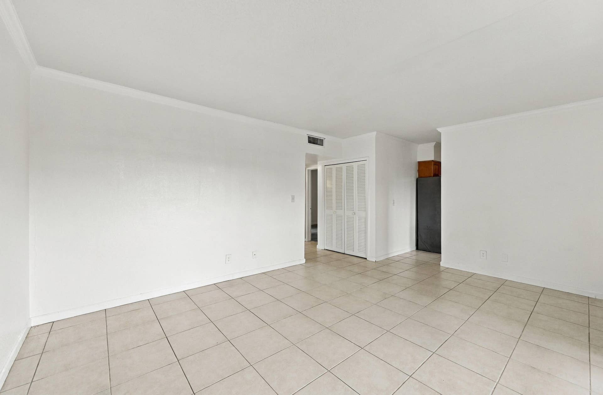 Neutral-toned tile flooring, white wall finishes, and bi-fold closet doors