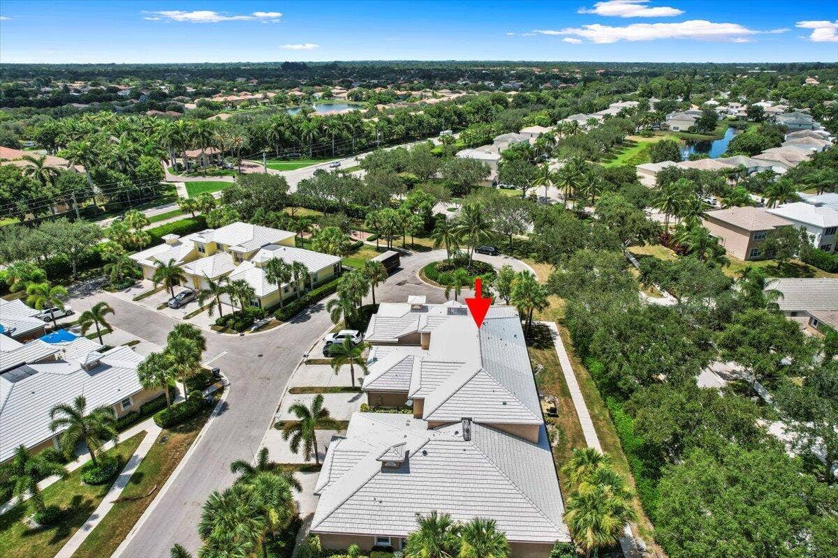 Elevated view showcasing the roof, nearby homes, and neighborhood greenery.