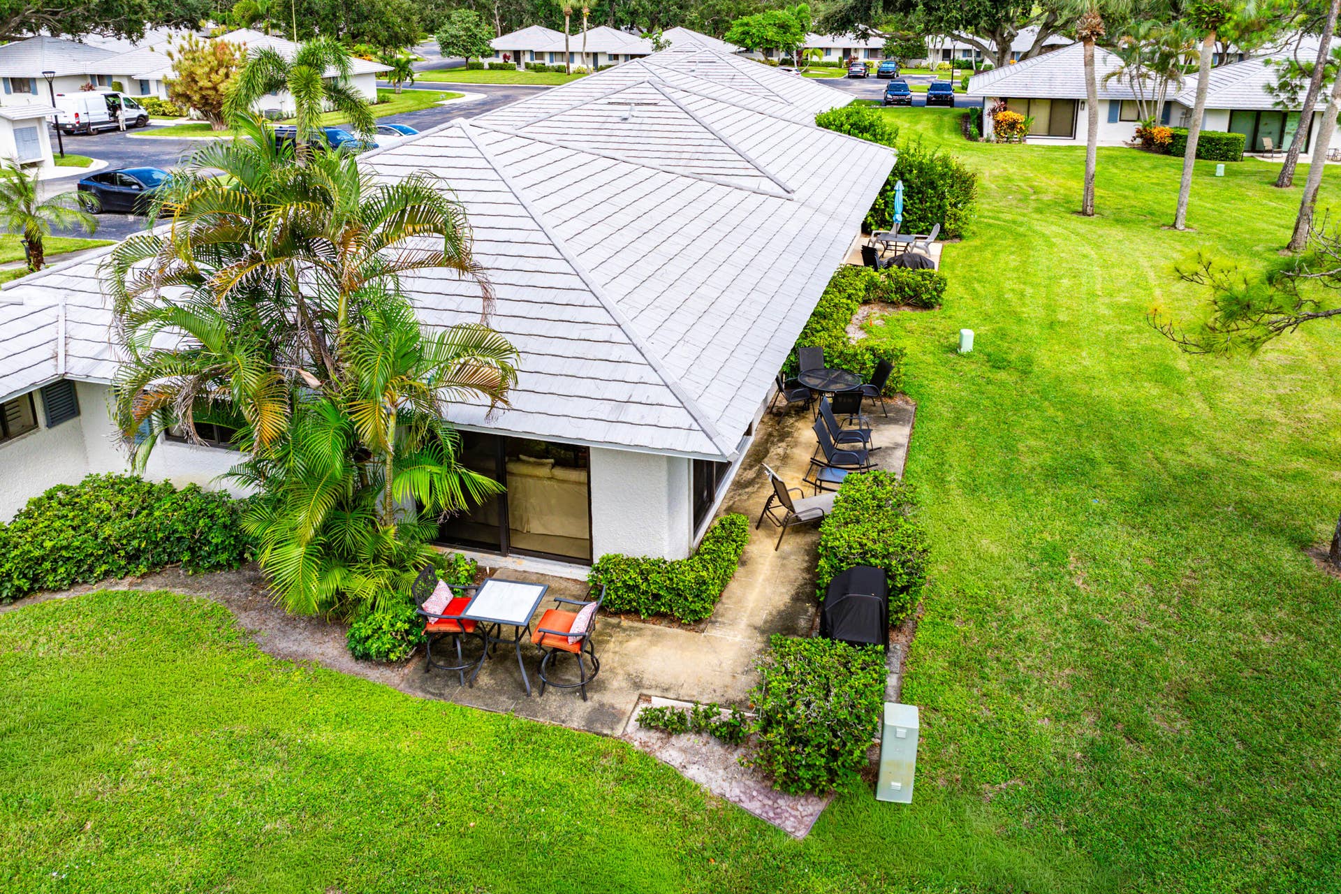526 Club Drive, Palm Beach Gardens, FL 33418 Single-story residence featuring a tile roof, concrete patio, and mature landscaping