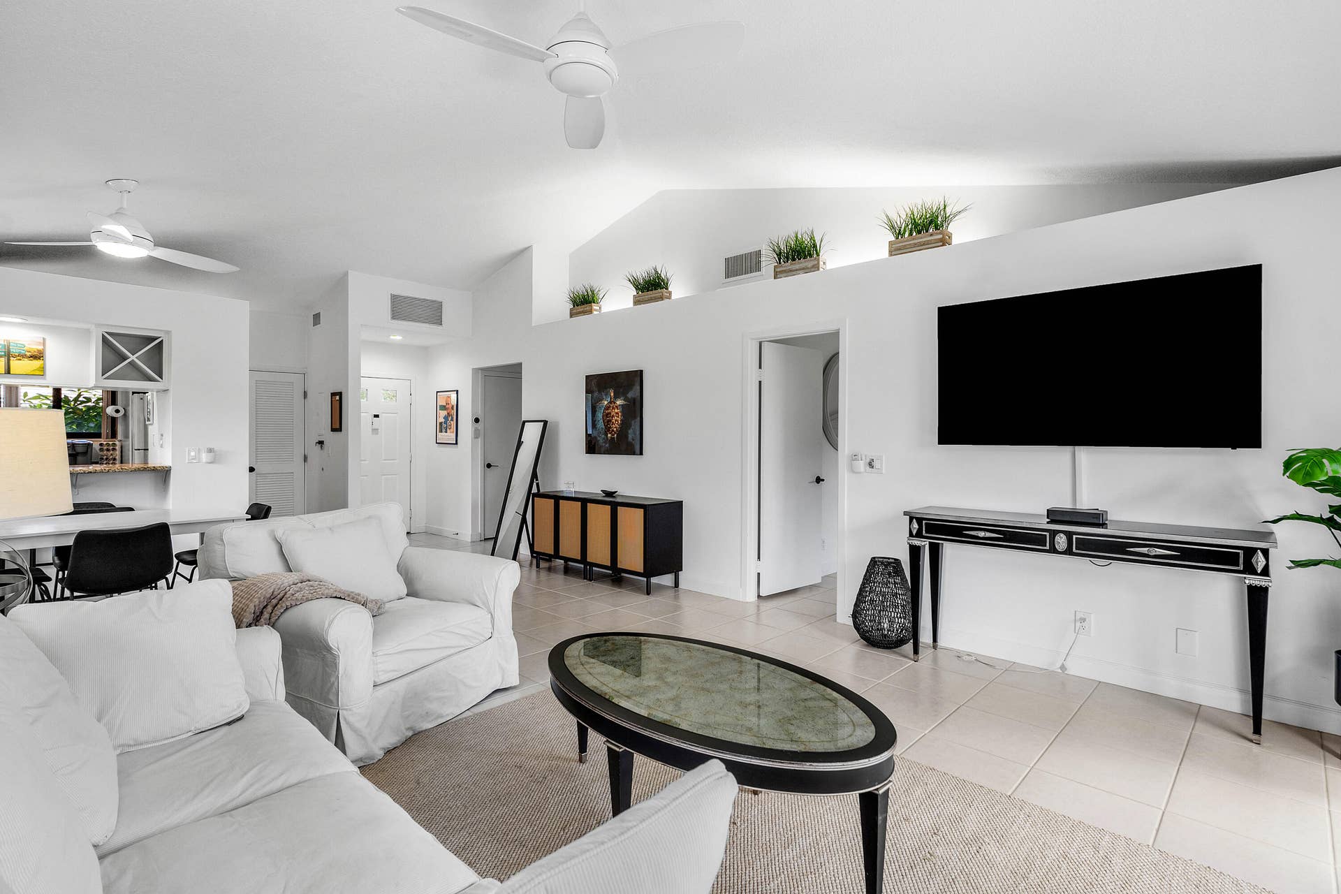 526 Club Drive, Palm Beach Gardens, FL 33418 Vaulted ceilings, neutral tile flooring, recessed architectural shelving, and dual ceiling fans